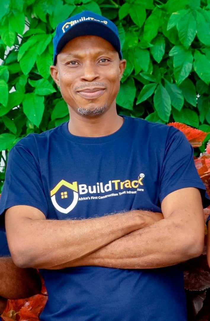 A BuildTrack representative in a branded BuildTrack cap and T-shirt, smiling with arms folded